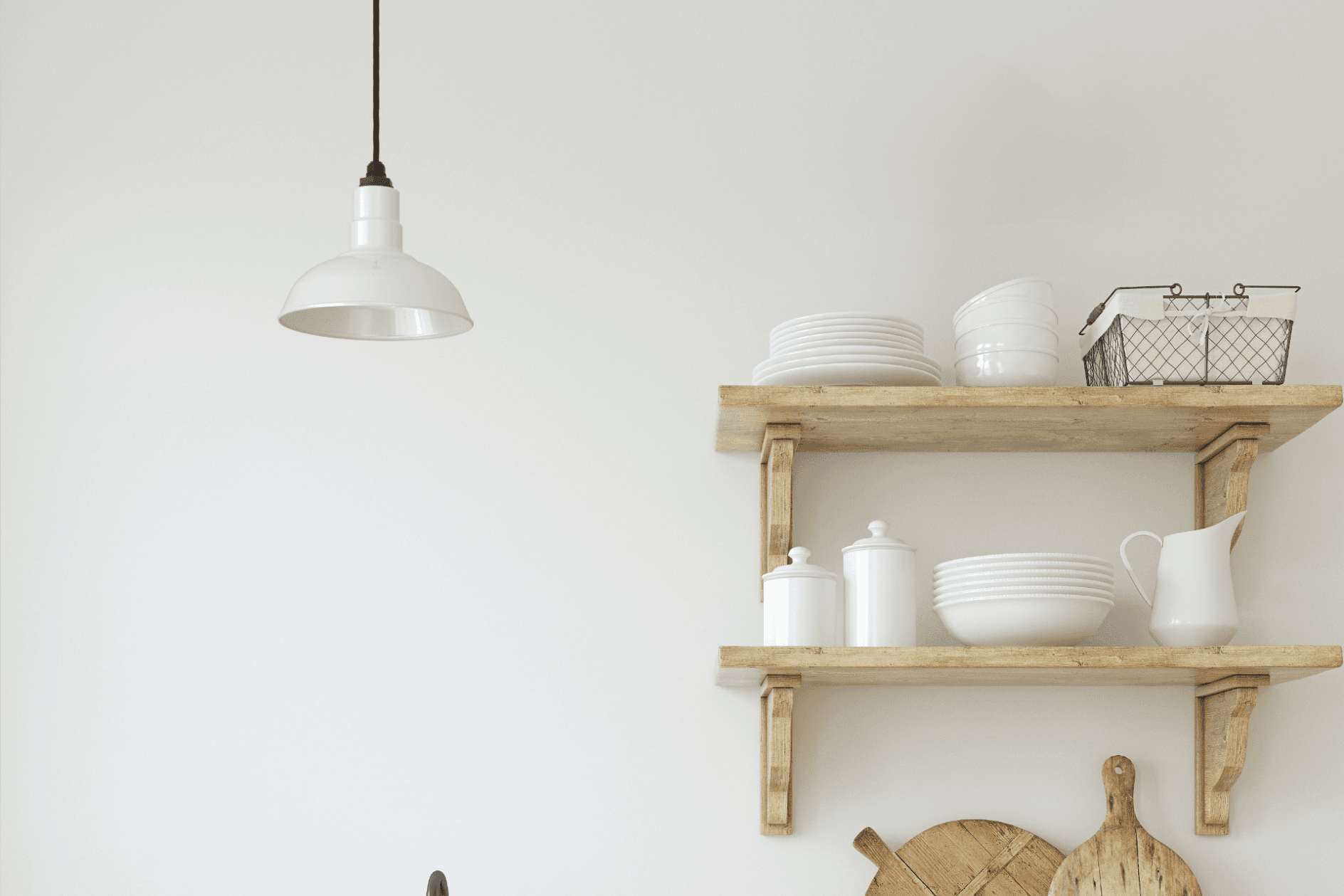 A sleek pendant light over rustic kitchen shelves with white dishes, creating a minimalist and warm ambiance.